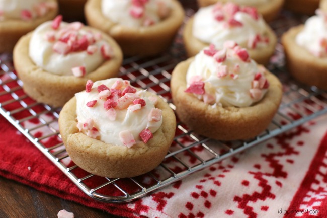 Nothing says, "It's Christmas time" quite like peppermint desserts! These soft sugar cookie cups hold a yummy cloud of peppermint cream cheese frosting! This perfect party confection is sure to impress!